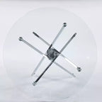 Elegante tavolo da pranzo dorato con ripiano in vetro e gambe incrociate