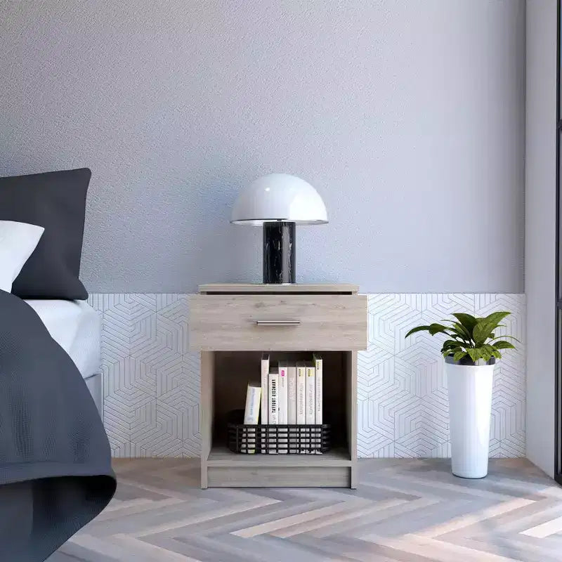 Con un design pulito e moderno, questo comodino 21H, con un cassetto, ripiano inferiore e ripiano superiore, di colore grigio chiaro, offre una soluzione pratica per riporre oggetti ed è robusto.