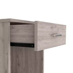 Con un design pulito e moderno, questo comodino 21H, con un cassetto, ripiano inferiore e ripiano superiore, di colore grigio chiaro, offre una soluzione pratica per riporre oggetti ed è robusto.