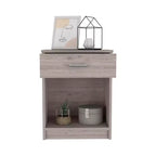 Con un design pulito e moderno, questo comodino 21H, con un cassetto, ripiano inferiore e ripiano superiore, di colore grigio chiaro, offre una soluzione pratica per riporre oggetti ed è robusto.