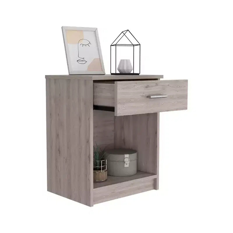 Con un design pulito e moderno, questo comodino 21H, con un cassetto, ripiano inferiore e ripiano superiore, di colore grigio chiaro, offre una soluzione pratica per riporre oggetti ed è robusto.