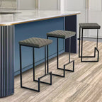 Sgabello da bar moderno in pelle trapuntata LeisureMod Quincy con struttura in metallo nero, sedia da bancone per isola cucina e posti a sedere a bancone